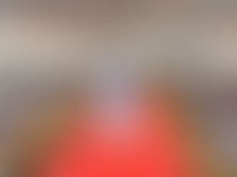 नीले कुर्ते में एक नेता टेंट के नीचे रेड कार्पेट पर हाथ हिला रहे हैं, जबकि भारी भीड़ जोश के साथ अपने हाथ और प्लेकार्ड ऊपर उठा रही है।