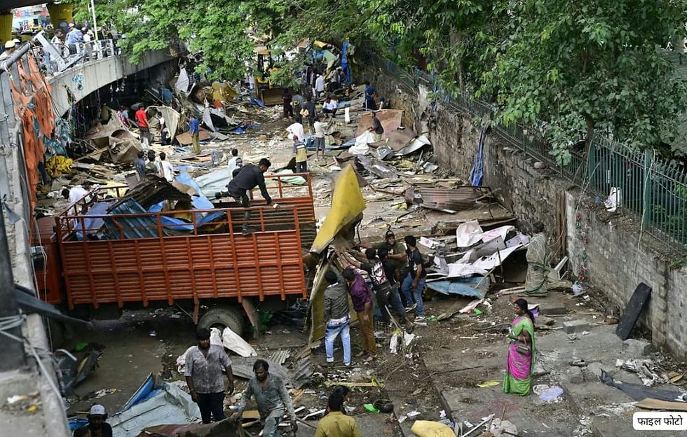 People clear debris and damaged structures beside a truck under a bridge, with trees overhead; file photo text visible.