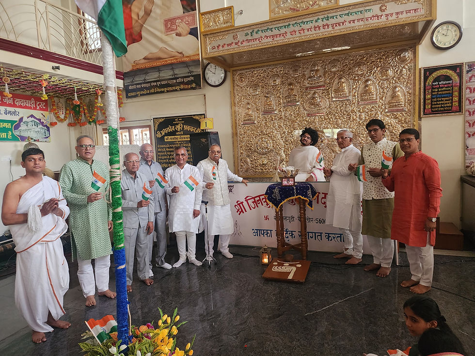 मंदिर हॉल में कई पुरुष भारतीय झंडे थामे खड़े हैं, पीछे सुनहरा नक्काशीदार पटल और हिंदी शिलालेख, उत्सवपूर्ण माहौल