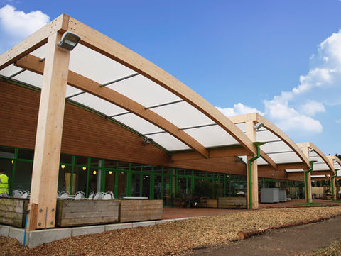 Modern wooden garden centre with curved roof, blue sky, garden centre consultants, PLEYDELL SMITHYMAN