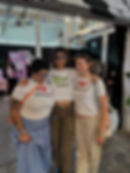 Three people wearing queer tshirts at an event