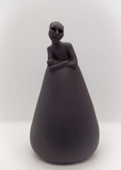 Hand modelled ceramic sculpture of human figure with cone shaped body, black stoneware.