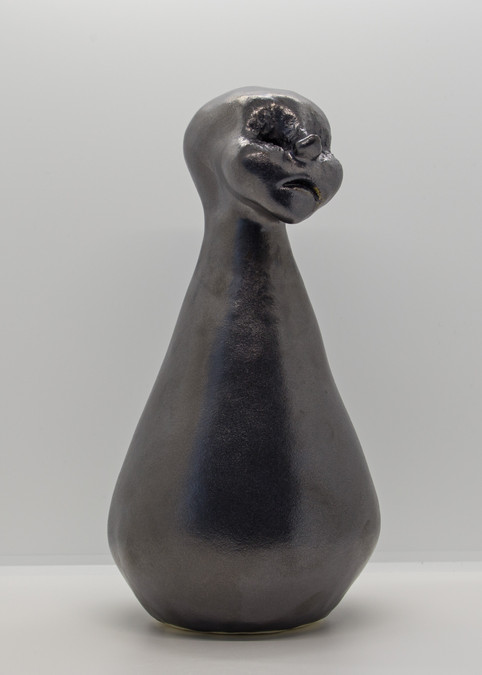 Hand modelled ceramic sculpture of human figure with cone shaped body, stoneware with metallic glaze.