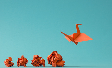 New ideas or transformation concept with crumpled paper balls and a crane, teamwork, creat