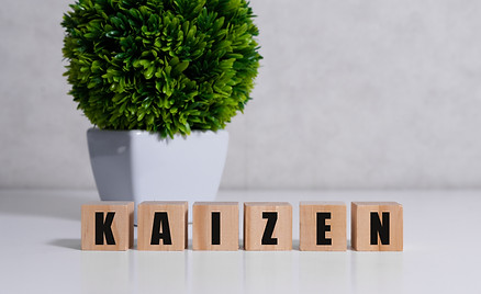 Kaizen improvement sign made of blocks on a wooden desk in a bright room.jpg