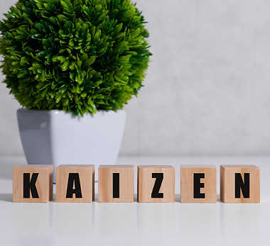 Kaizen improvement sign made of blocks on a wooden desk in a bright room.jpg