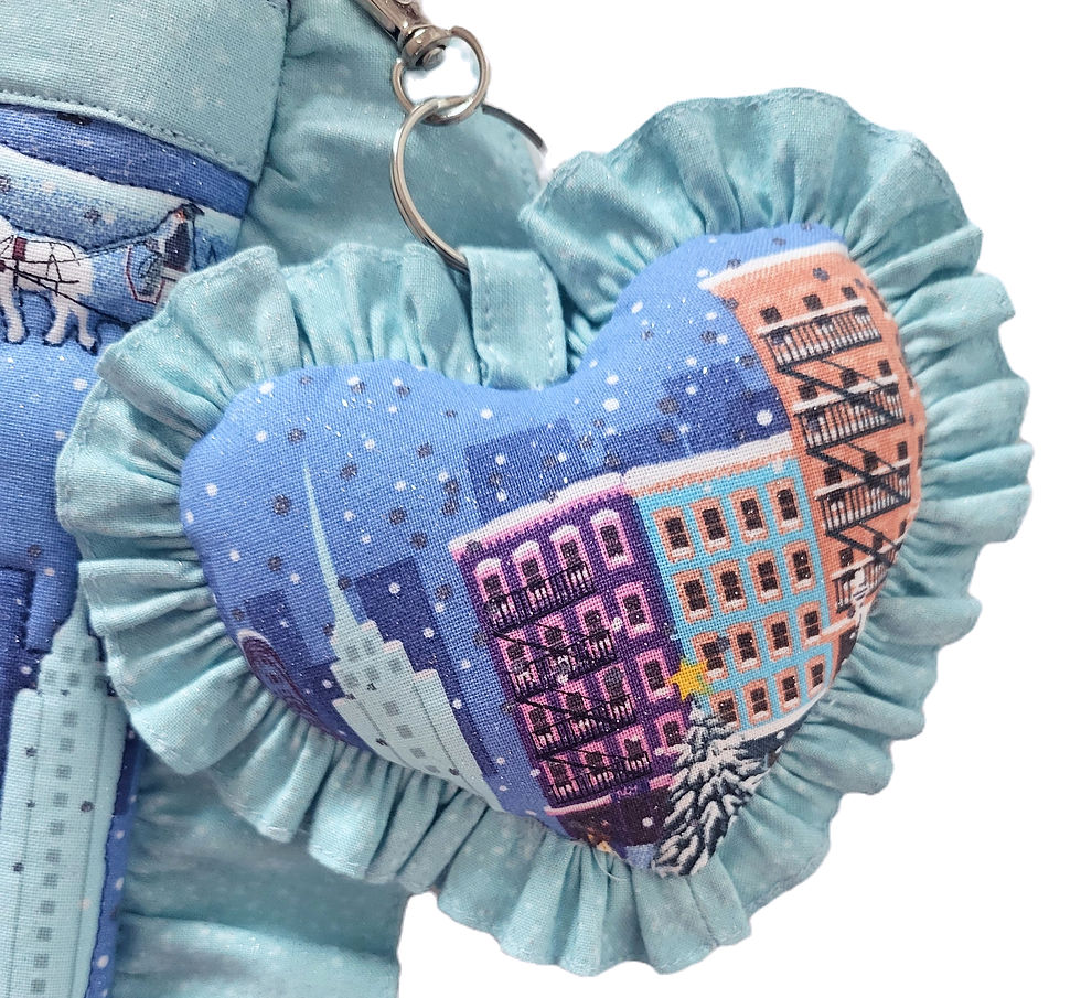 Thumbnail: close up of frilled heart shaped bag charm sewn in Fairytale in New York print in colours of blues, white and silver