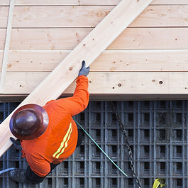 Construction Worker Lifting Wood Board