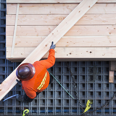 Construction Worker Lifting Wood Board