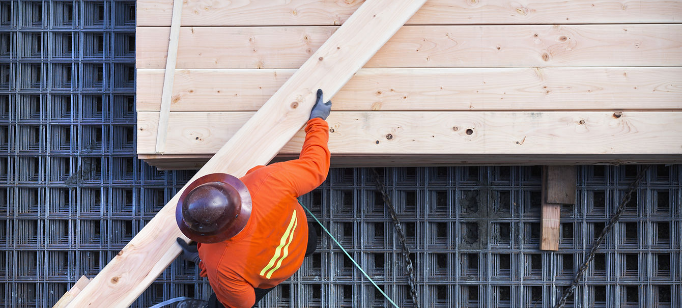 Construction worker lifting wood board
