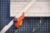 Construction worker lifting wood board