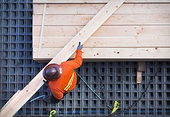 Construction Worker Lifting Wood Board