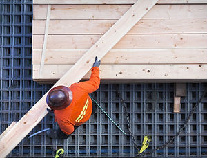 Construction Worker Lifting Wood Board
