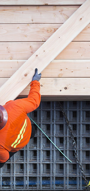 Construction worker lifting wood board