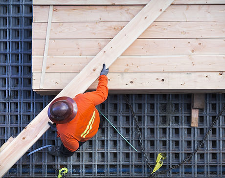 Construction Worker Lifting Wood Board