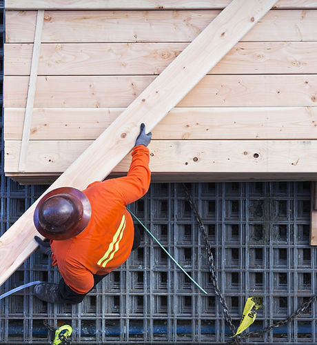 Construction Worker Lifting Wood Board