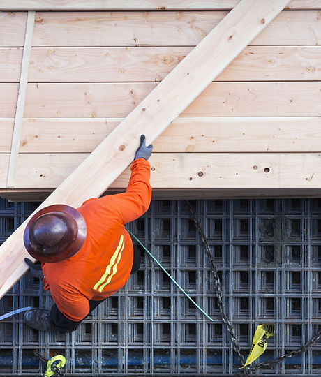 Construction Worker Lifting Wood Board