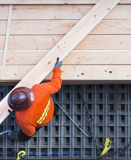 Construction worker lifting wood board