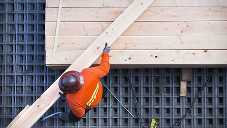 Construction worker lifting wood board