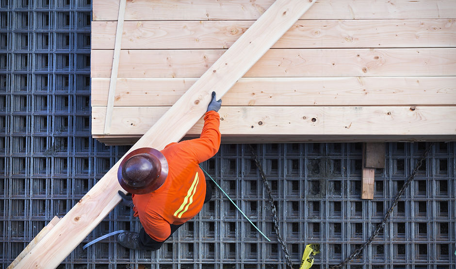 Construction Worker Lifting Wood Board