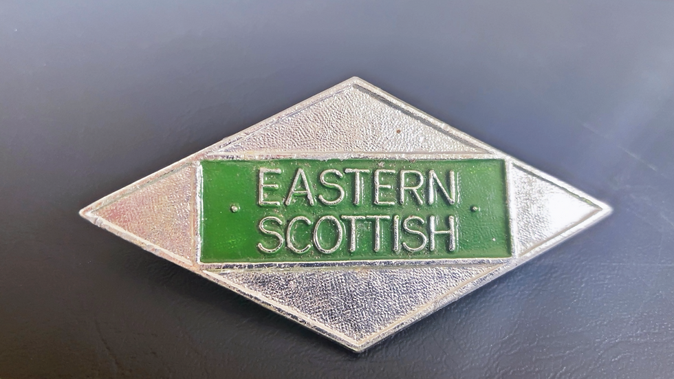 silver and green bus drivers badge