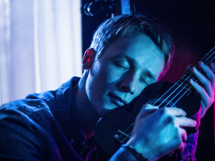 man playing the ukulele and loving it