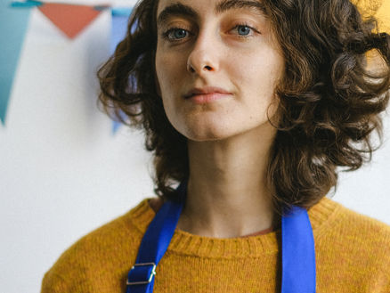 woman with blue apron looking confident