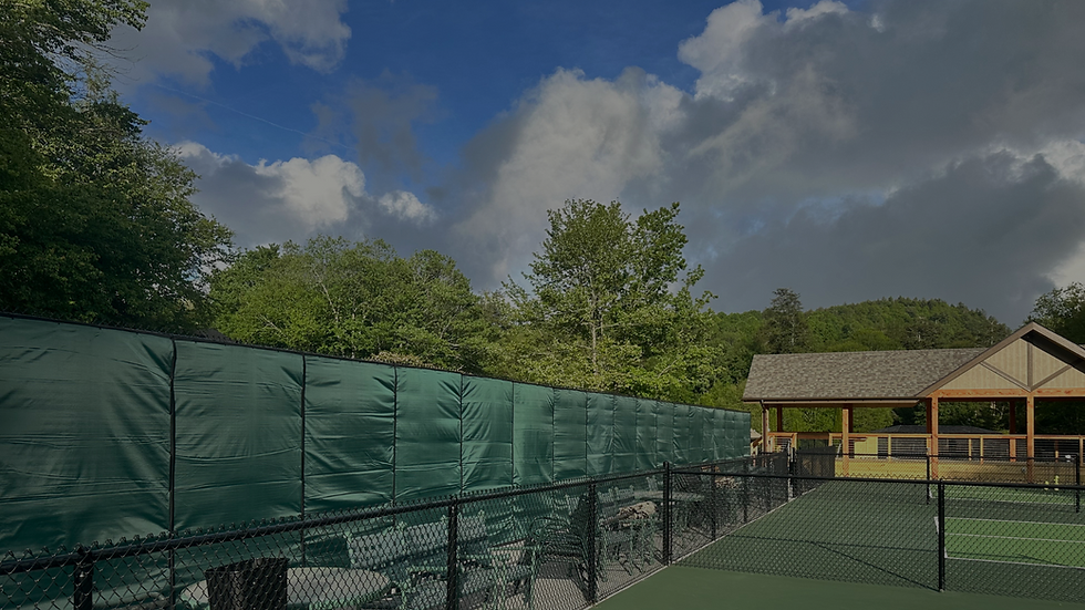 Eye-level view of outdoor pickleball court with surrounding fencing