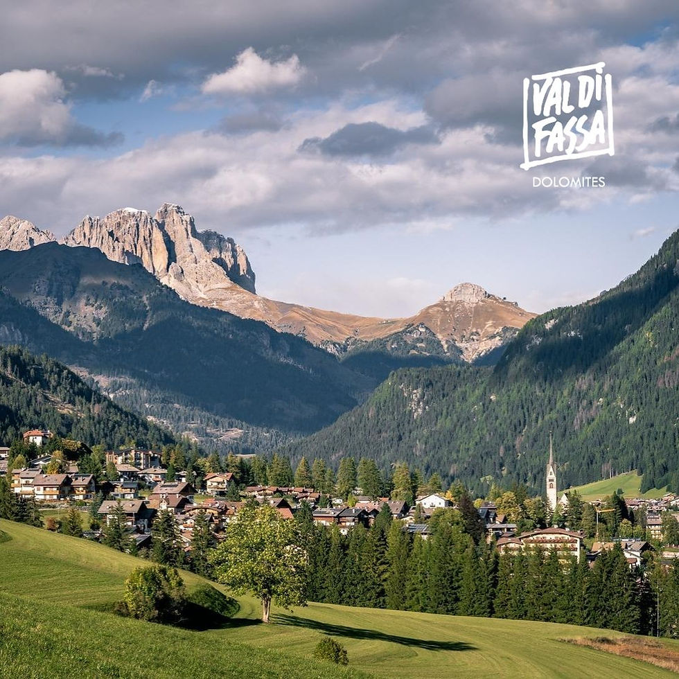 Vigo di Fassa in estate con le Dolomiti e i prati verdi della Val di Fassa
