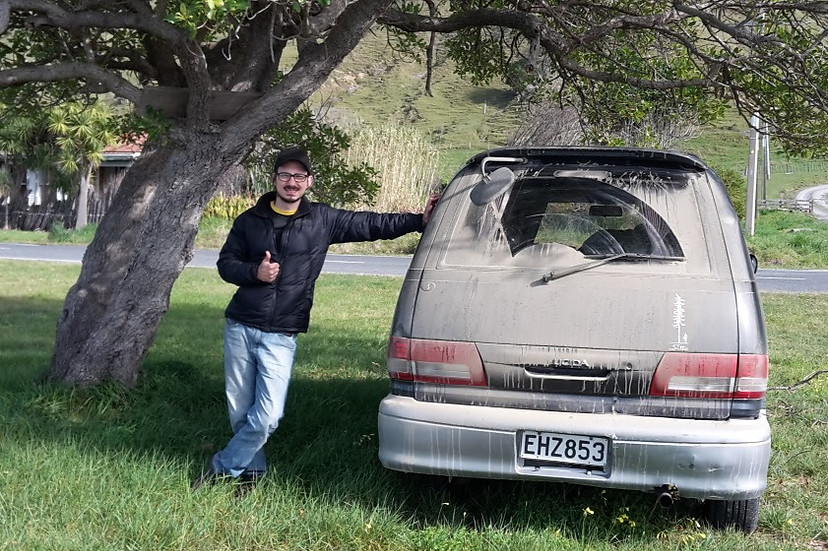 Rafa Ferreira encostado em uma van suja de terra na Nova Zelandia