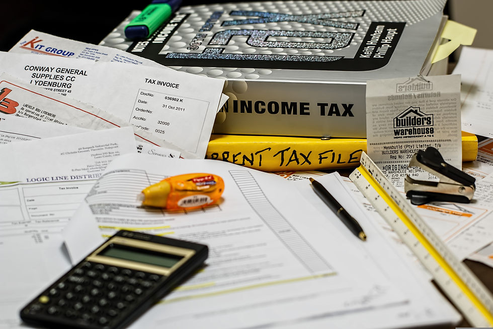 scattered papers beneath calculator and tax books