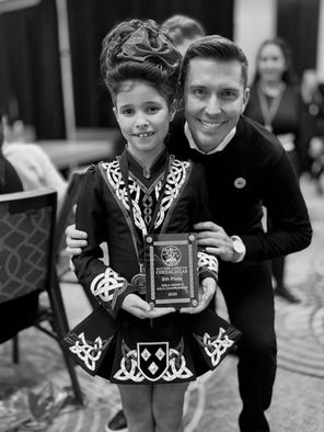 Casey Costello ADCRG standing with dancer holding a plaque at a feis
