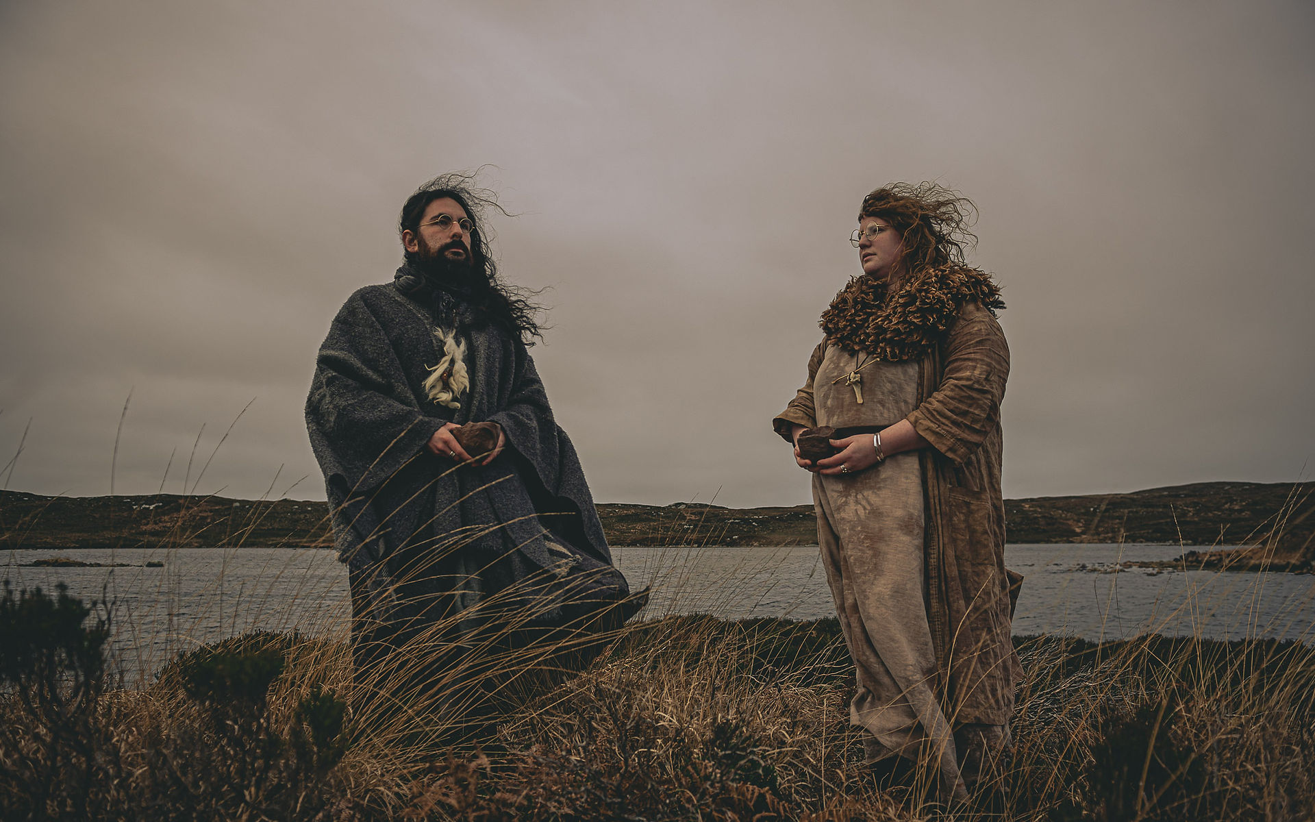 Fantasy witch couple exchange gifts of clay in this dark fantasy aesthetic photoshoot on the Isle of Coll, in the Hebrides, Scotland. Facing the Camera
