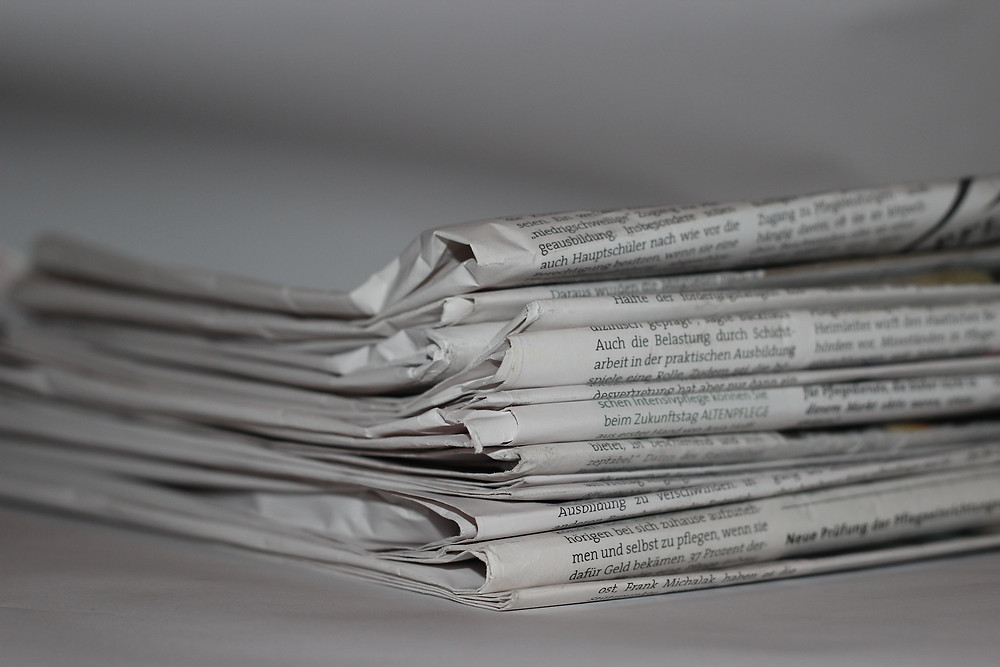 Black and white newspapers stacked up