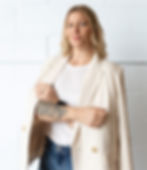 Image of Dr. Caitline Sembach, of Sembach Chiropractic, in a white blazer with her arms folded.
