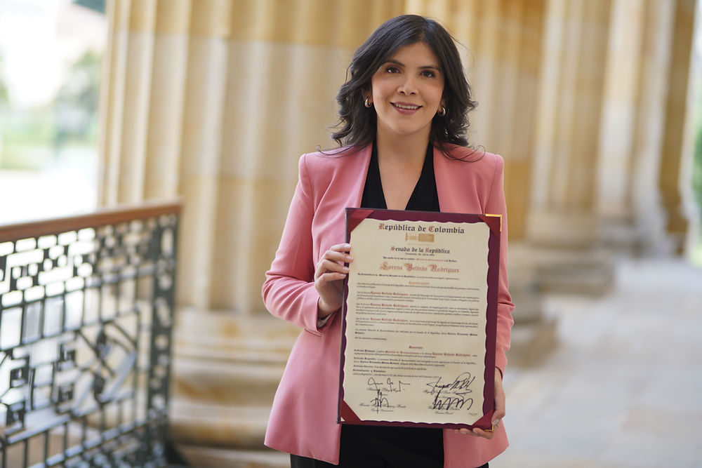Lorena Beltrán, periodista bilingüe, sostiene un documento.