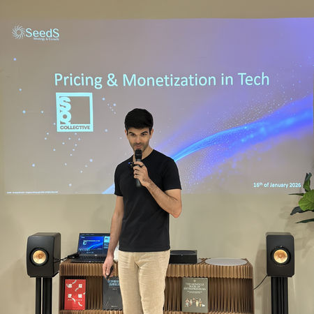 SQ Collective event: Solo presenter on stage, holding a microphone, with 'Pricing & Monetization in Tech' slide visible behind them.