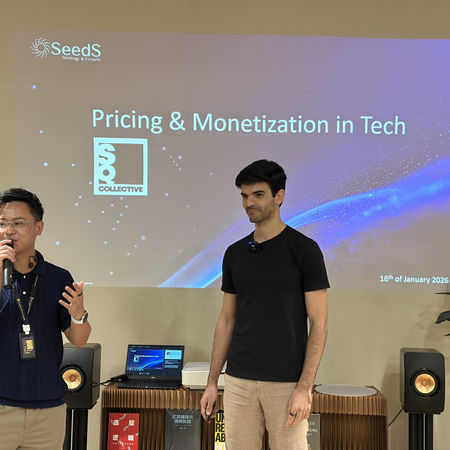 SQ Collective event: Presenter speaking into a microphone, another person listening.
