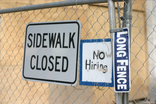 A "No Hiring" sign alongside other signs, weburbanist.com.