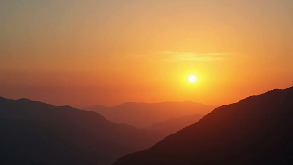 Wide angle view of a sunset behind mountains