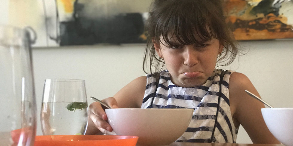 girl pouting over soup