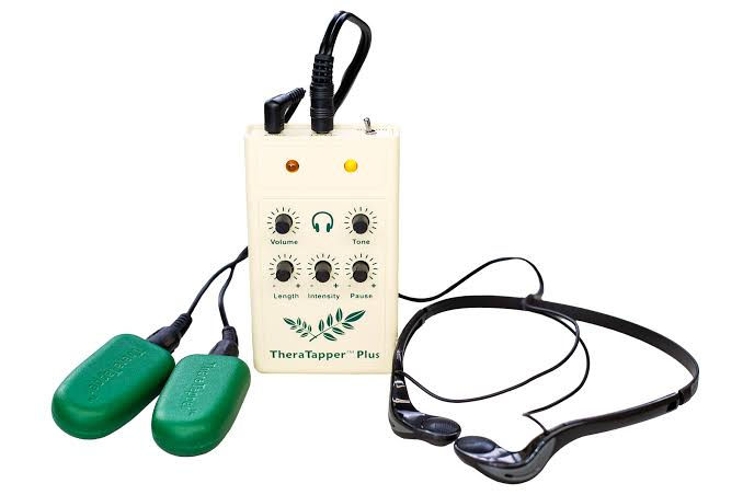 TheraTapper Plus device with accompanying green tappers and audio headset, designed for therapeutic applications.