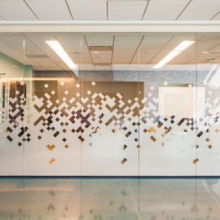 Glass-enclosed meeting room with decorative privacy film and modern interior finishes within the KCPL Safety & Training Facility.