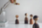 a wooden figure of a boy standing away from the family