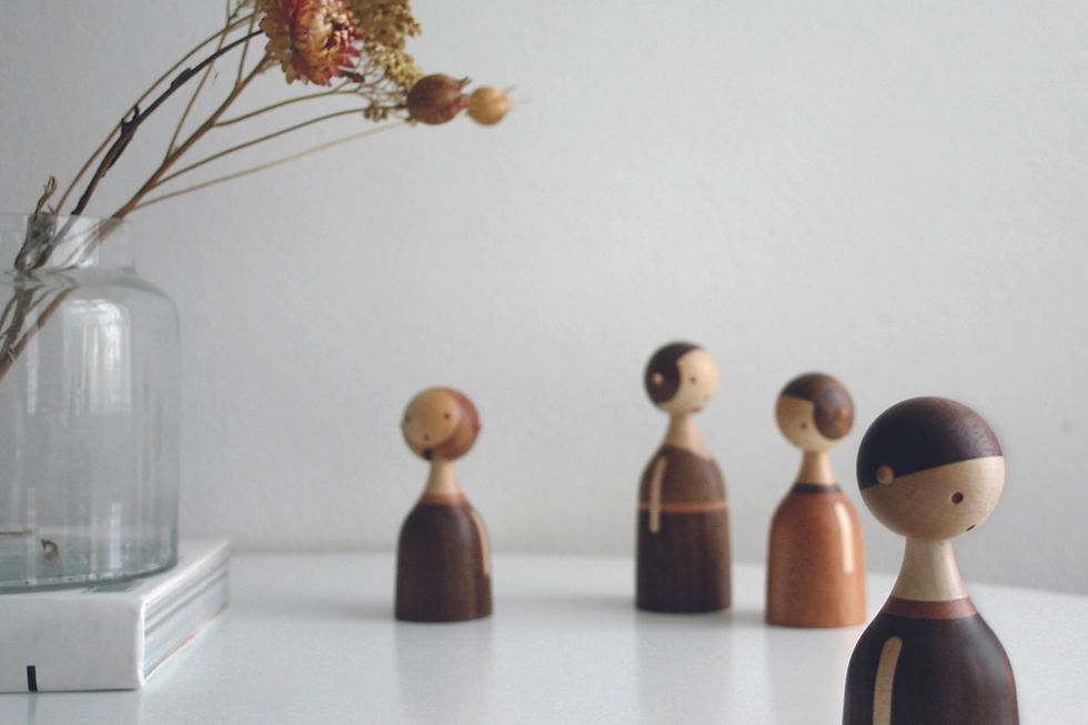 a wooden figure of a boy standing away from the family