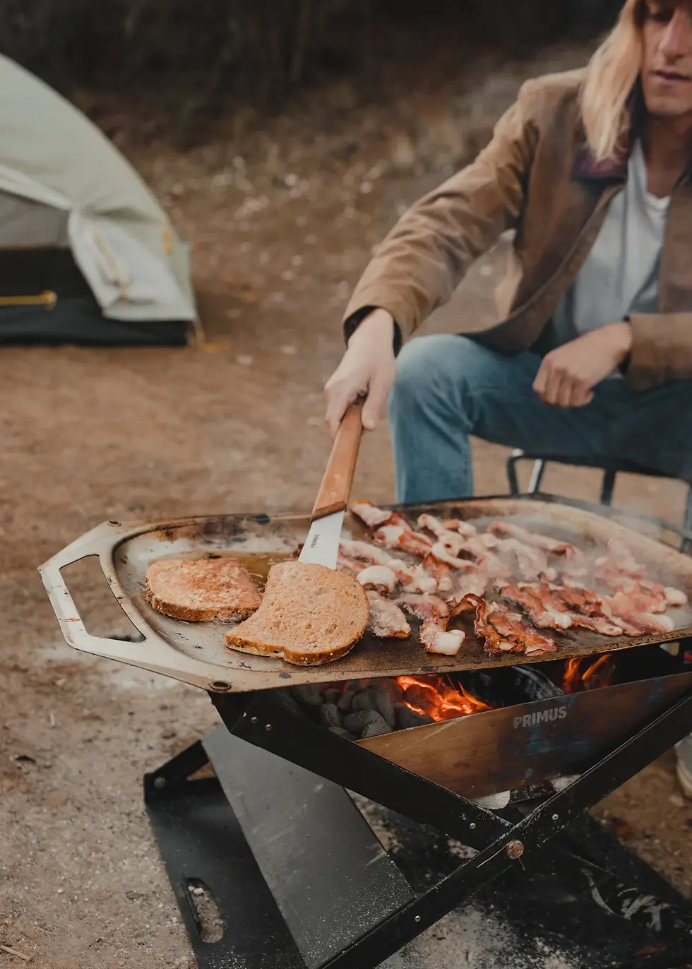 a lady cooking on a Primus - OpenFire Pan - Small