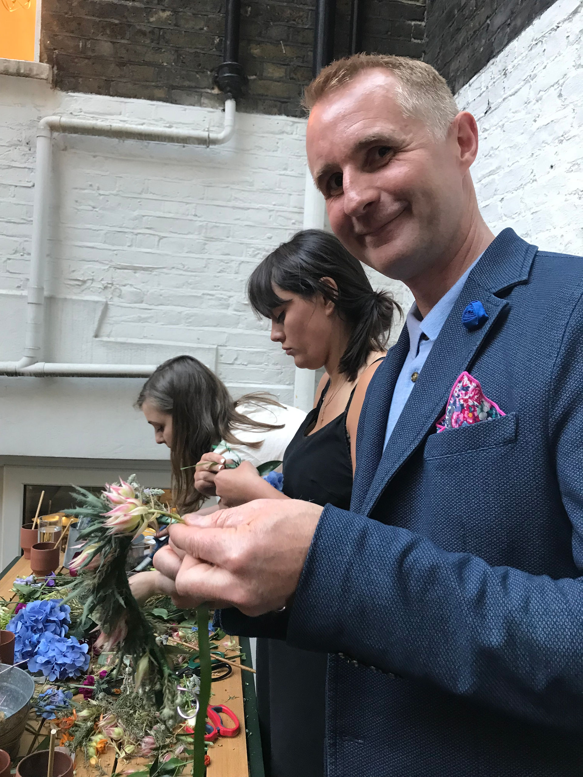 a man smiling and making a flower ring