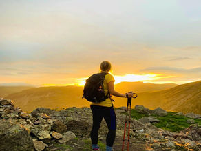 a person on a mountain looking at the sunrise
