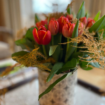 Double orange tulips in a antique vase by blomster designs flowers