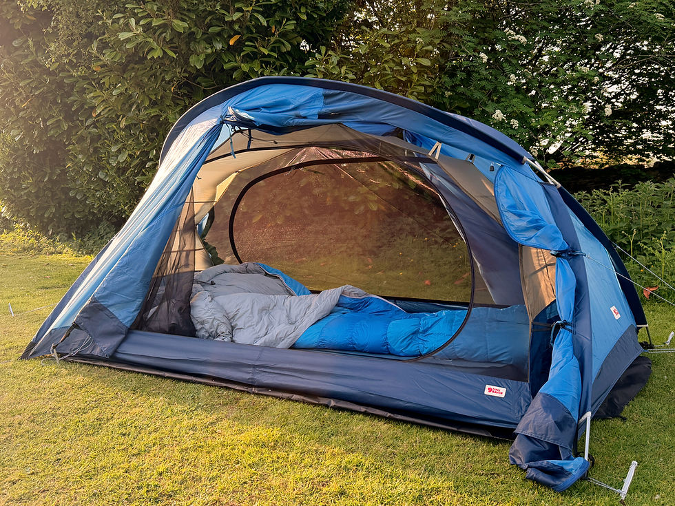 fjallraven abisko view tent in un blue with the sides open on golden sunlight